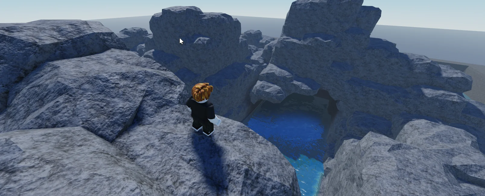 WorldLoop rocky voxel cave opening onto a pool of water in Roblox Studio
